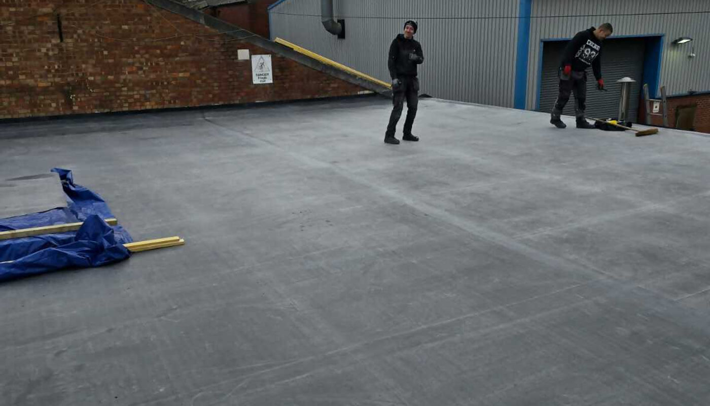 J5 Roofing team surveying a large commercial flat roof in Birmingham