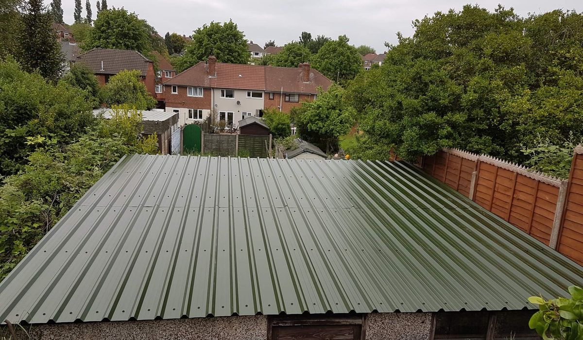 Converted garage roof in green metal sheeting surrounded by gardens in Birmingham