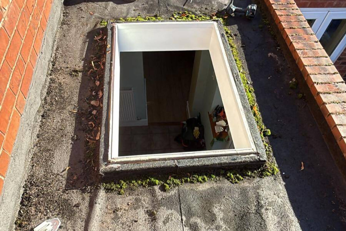 Before: old moss-covered flat roof with a deteriorating skylight opening